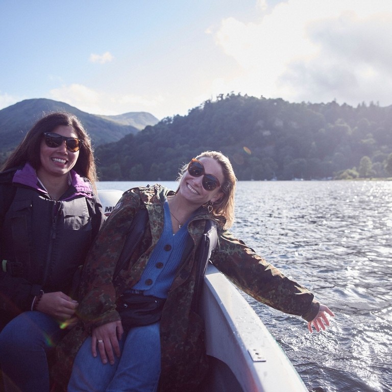 Two women wearing sunglasses on a boat on the lake