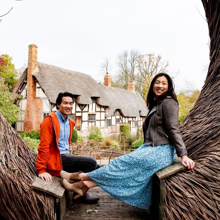A young couple at Anne Hathaway's Cottage sitting on Tom Hare's 'The Moon Seat', Stratford-upon-Avon, Warwickshire, England
