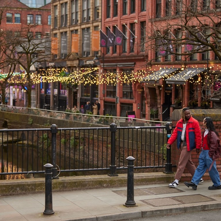 Two men chatting, exploring canal side shops.