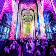 Group of people looking and photographing light show in a cathedral